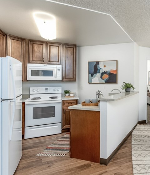 A kitchen with white appliances and wooden cabinets.