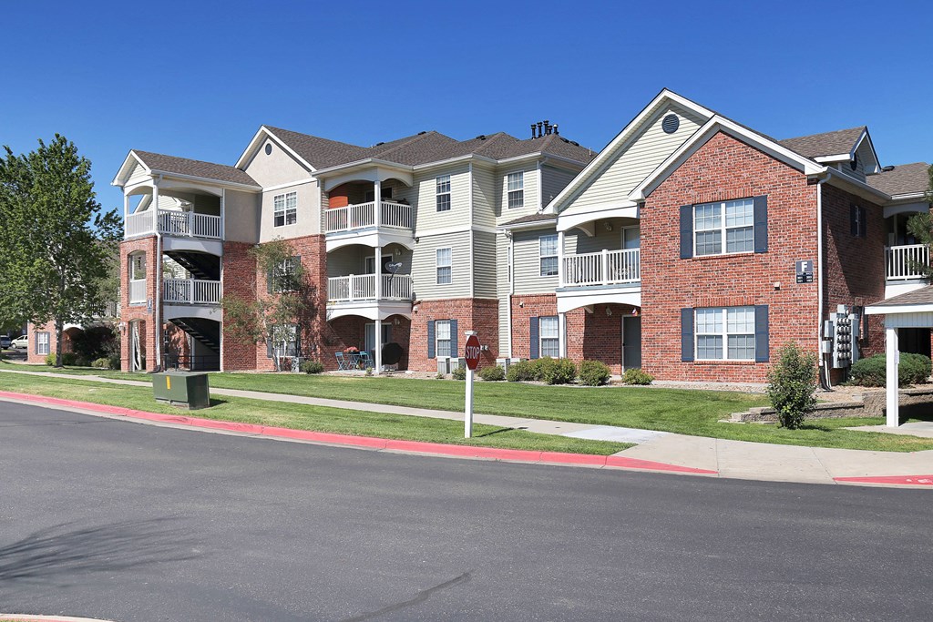 Apartment building with a red brick facade and multiple balconies.