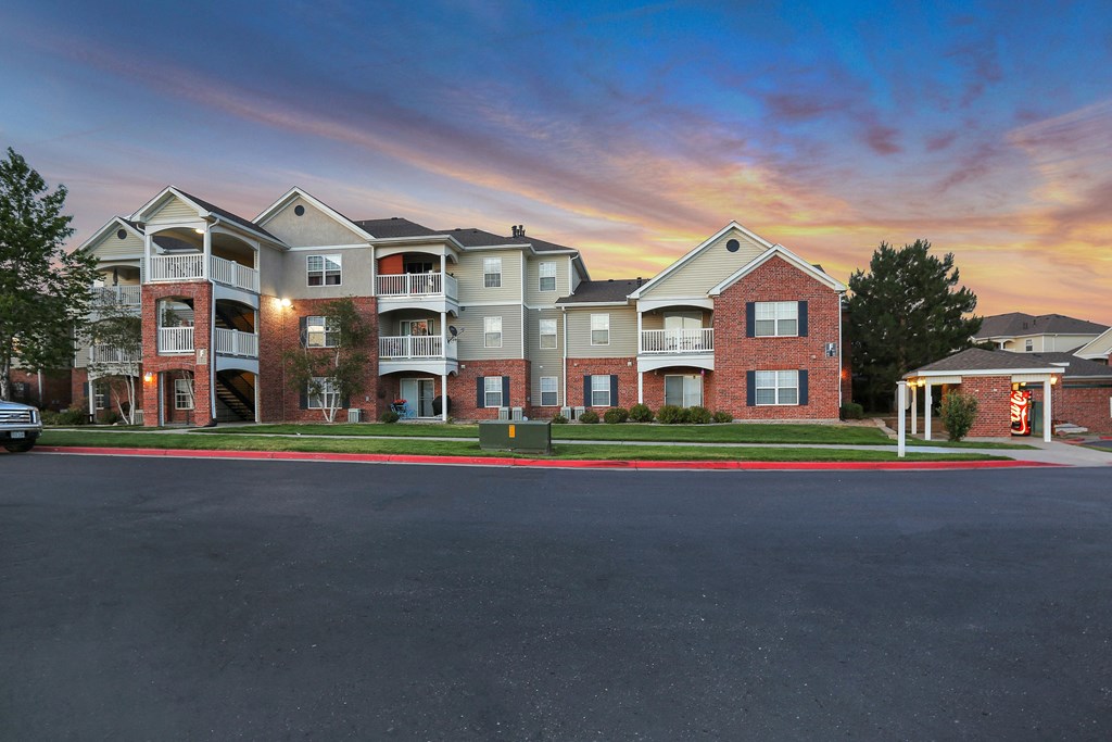 A row of apartment buildings with a car parked in front.