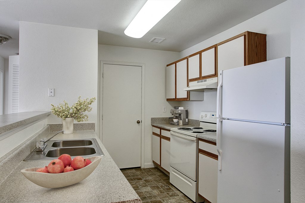 A kitchen with a bowl of apples on the counter.