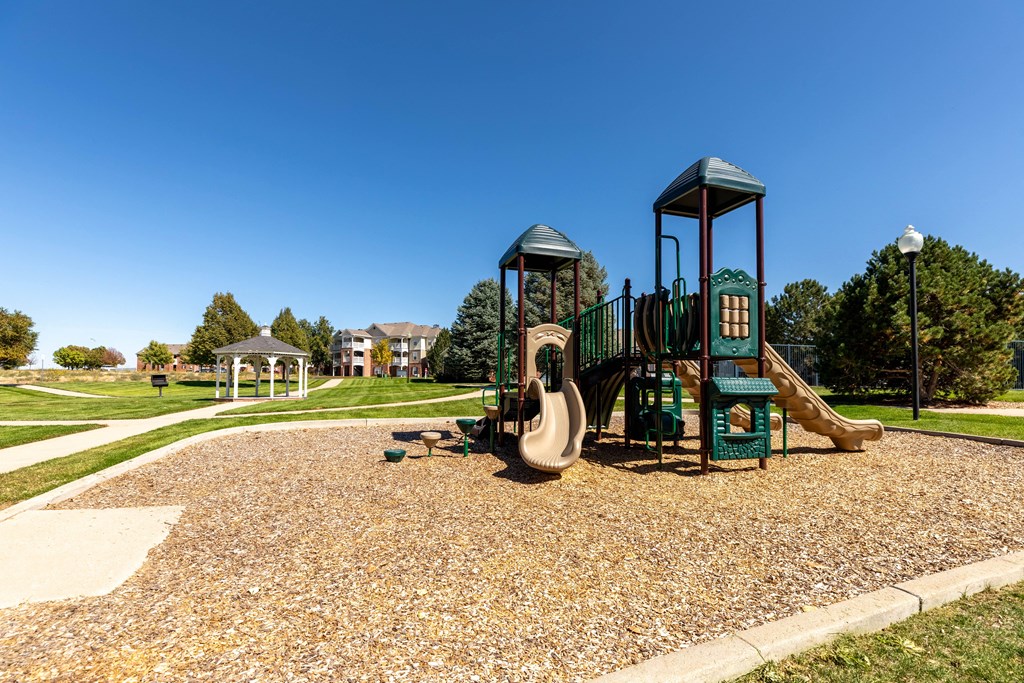 A playground with a green slide and a yellow slide.