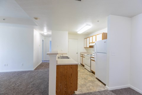 A kitchen area with a white refrigerator and wooden island.