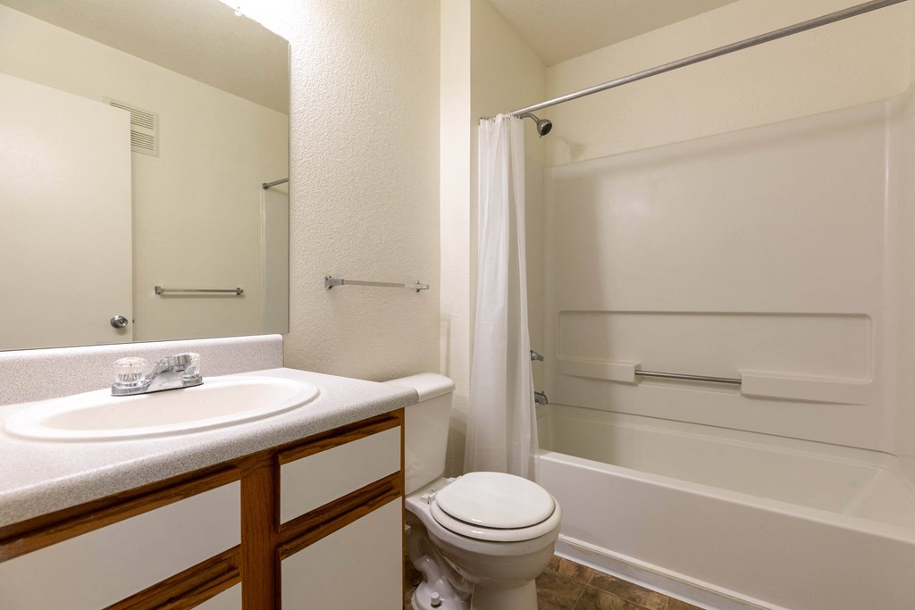 A white bathroom with a toilet, sink, and bathtub.