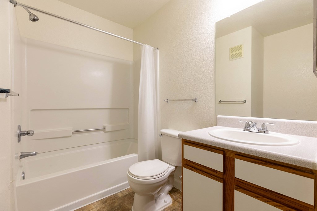 A white bathroom with a toilet, sink, and bathtub.