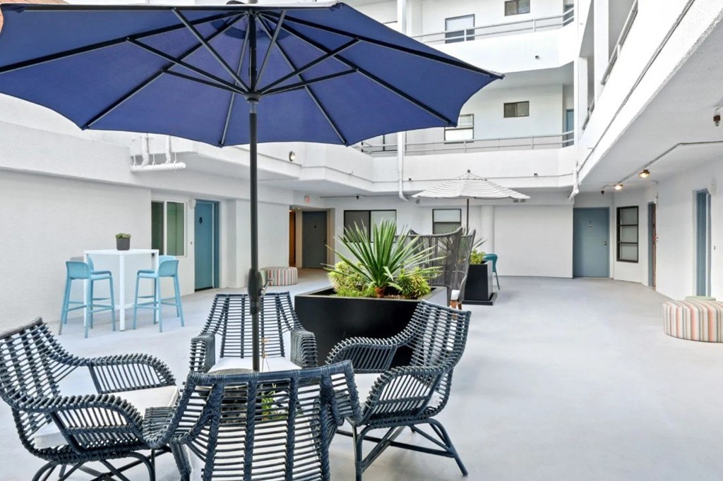 A patio with a table and chairs under an umbrella.