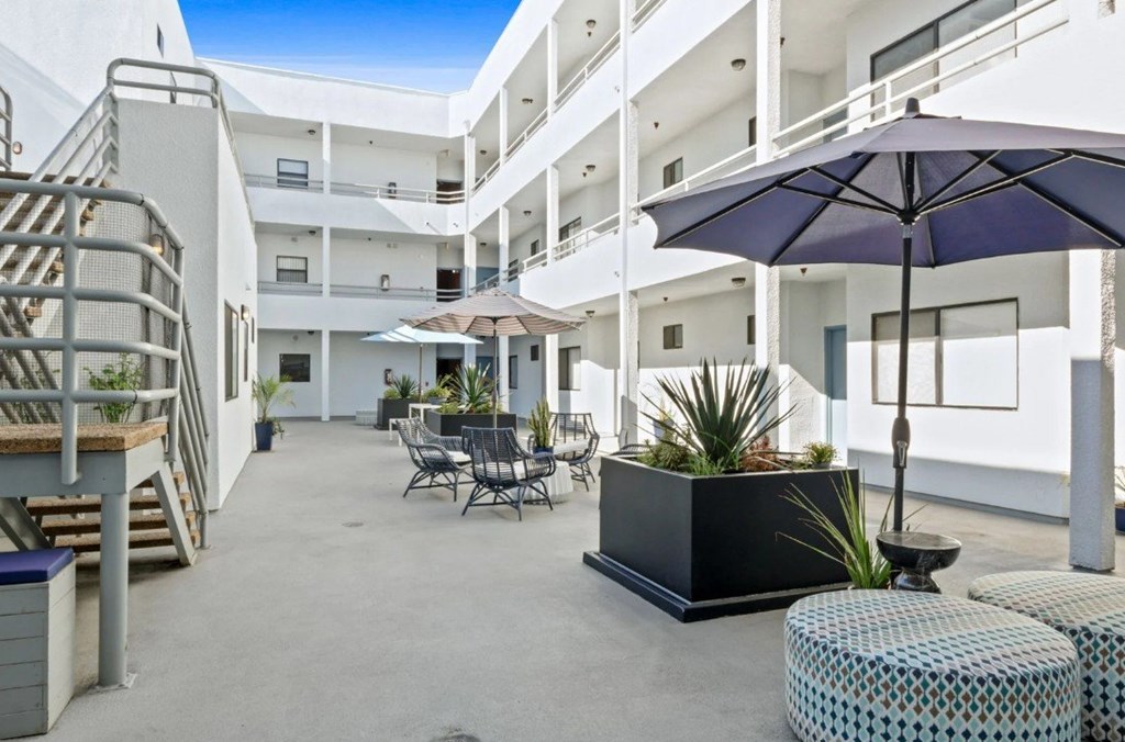 A patio area with a table, chairs, and an umbrella.