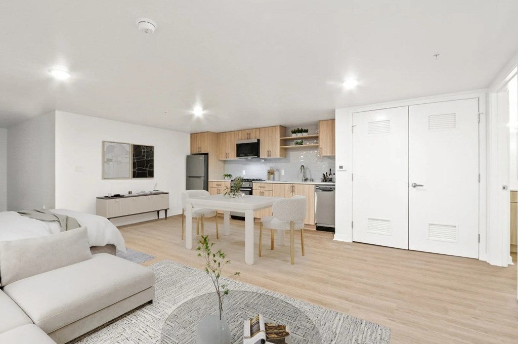 A modern kitchen with white cabinets and a dining table with chairs.