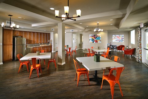 a dining room with tables and chairs and a kitchen