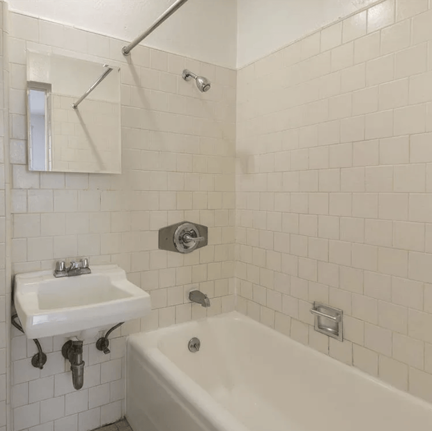 a white bathroom with a sink and a tub