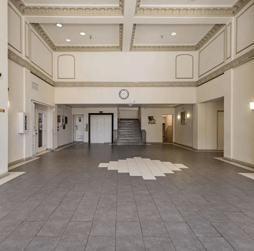 a large room with a clock on the wall and a staircase