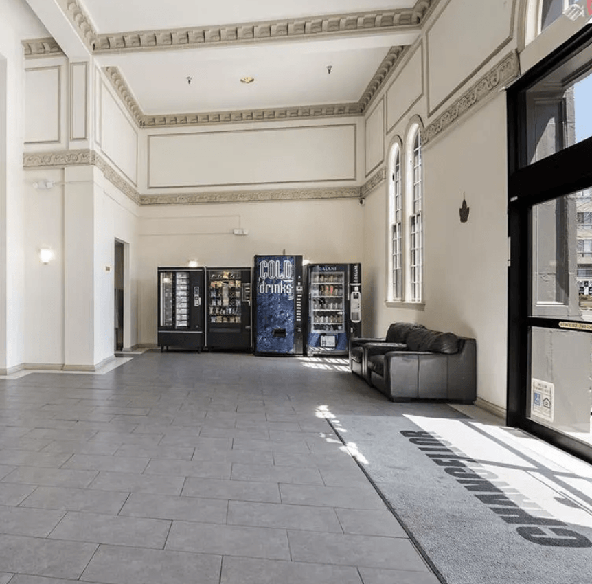 the lobby of a building with a couch and vending machines