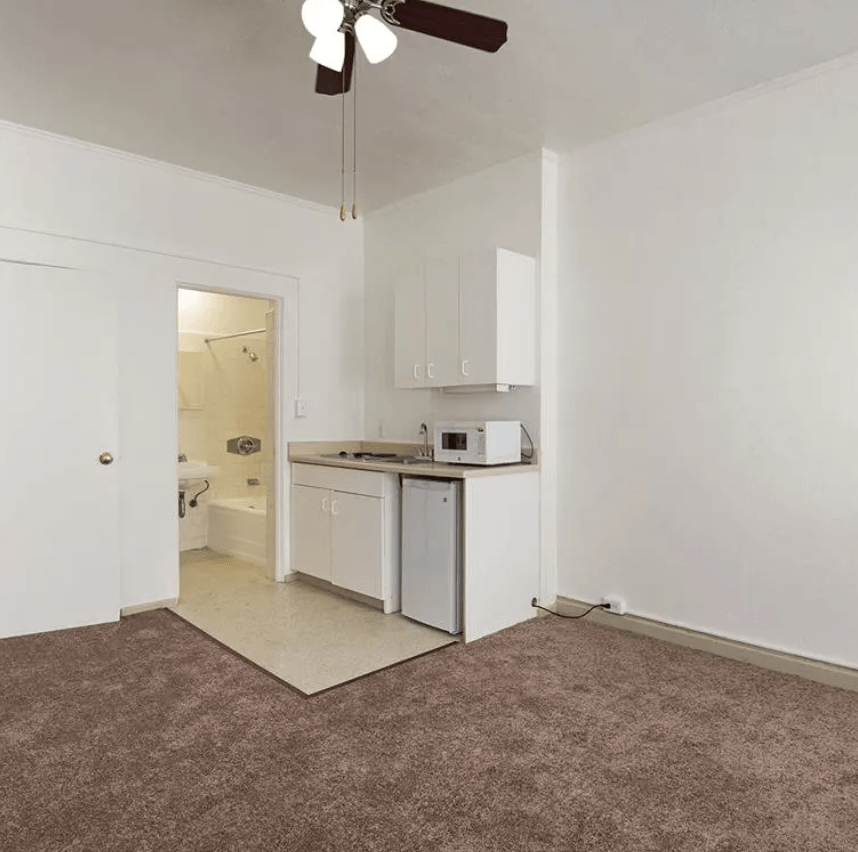 an empty kitchen with a microwave and a sink
