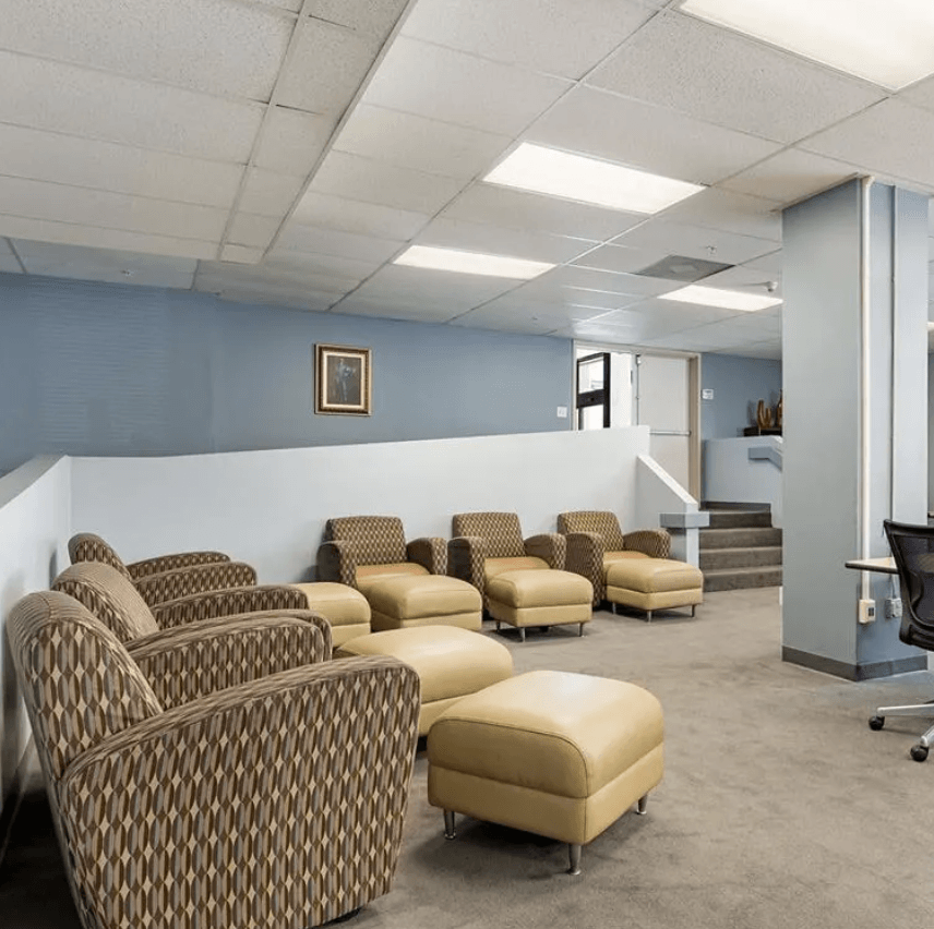 a waiting room with a row of chairs and a table