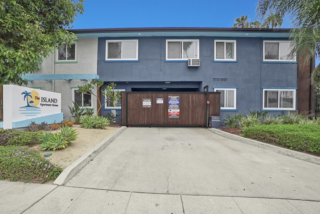 The Island Apartments is a blue building with a sign in front.