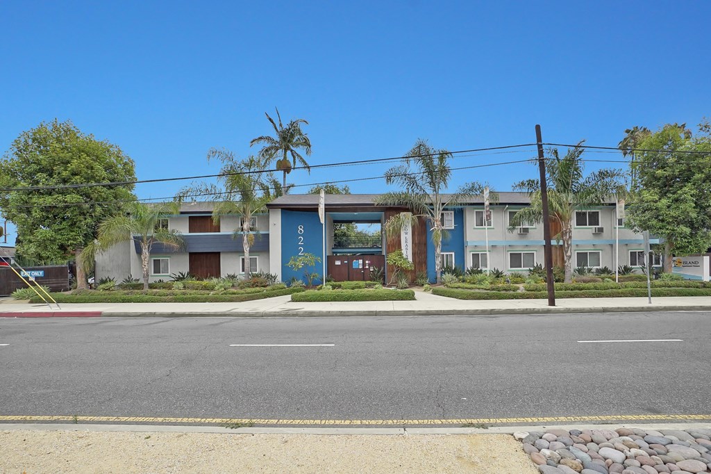 A street view of a residential area with houses and a clear blue sky.