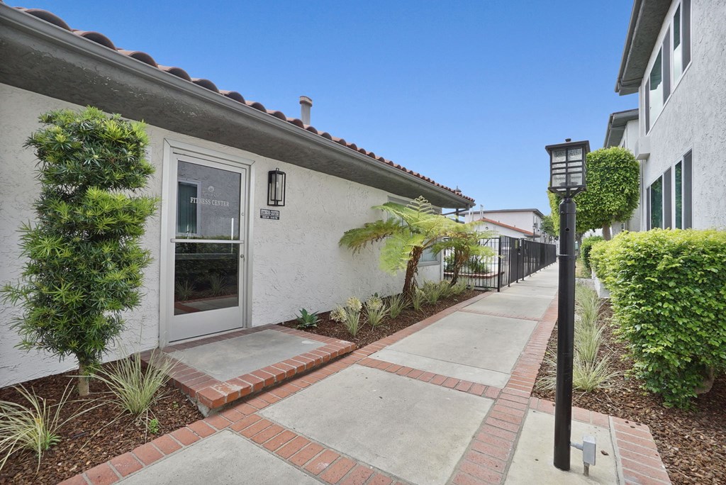 a walkway with a lamp post in front of a white building
