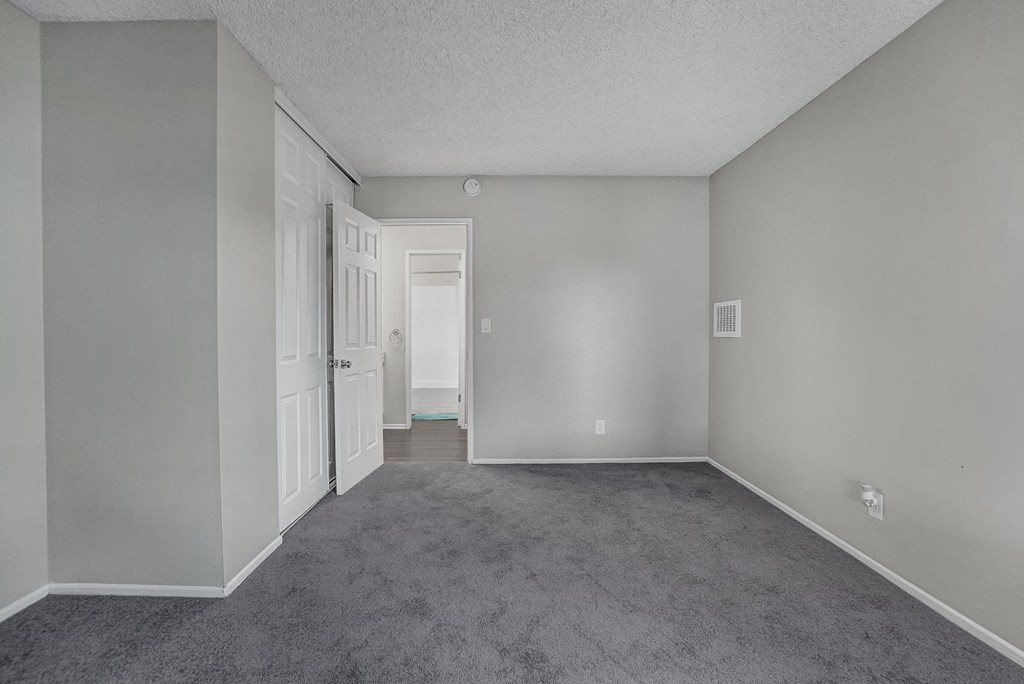 a bedroom with gray carpet and a white door