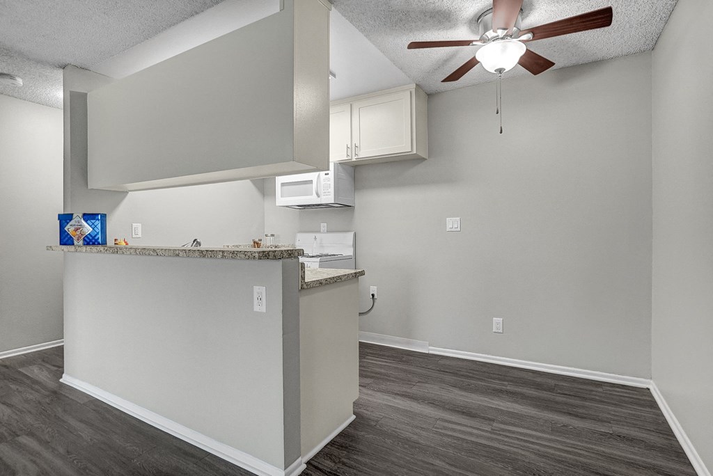 a kitchen with a counter top and a ceiling fan