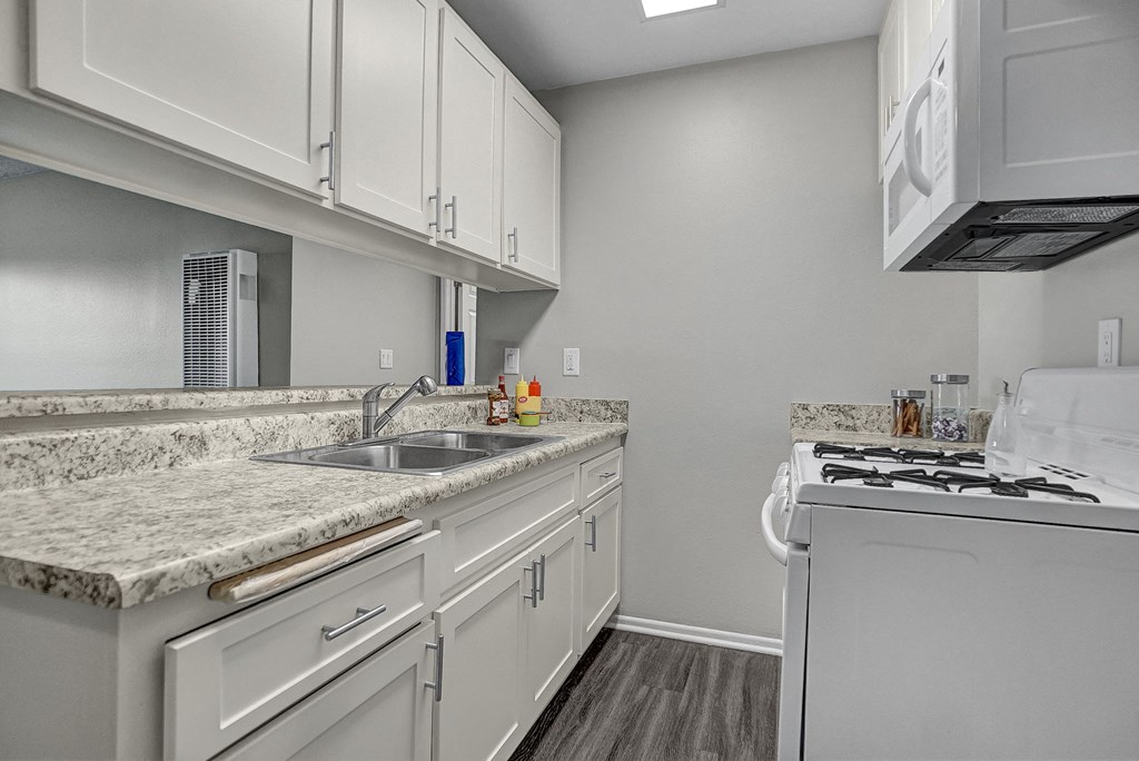 a kitchen with white cabinets and a white stove top oven