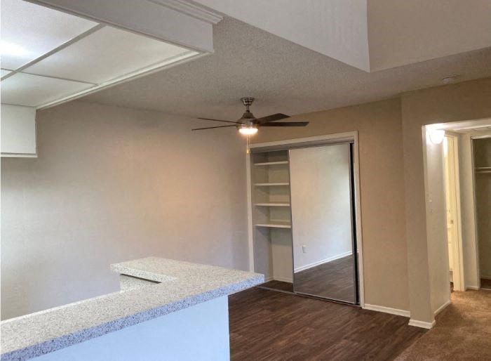 A room with a ceiling fan and a counter.