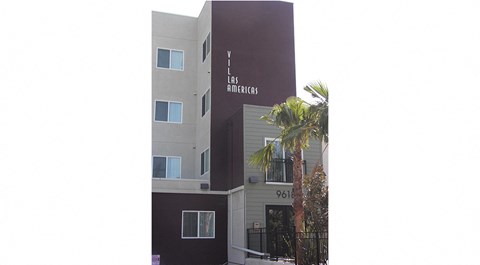 an apartment building with a palm tree in front of it