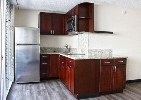 a kitchen with wooden cabinets and a stainless steel refrigerator