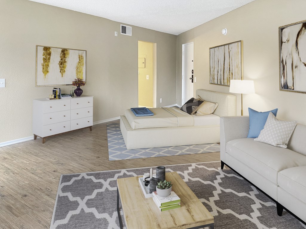 a bedroom with a bed couch and dresser in a 555 waverly unit