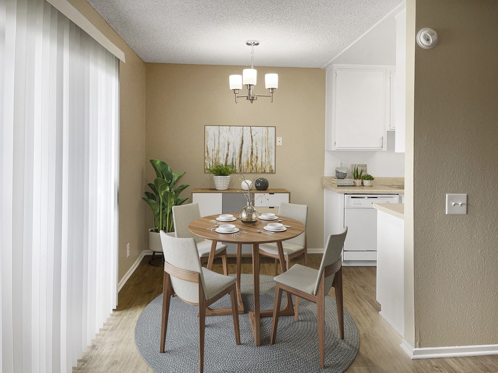 a dining room with a table and chairs and a kitchen in the background