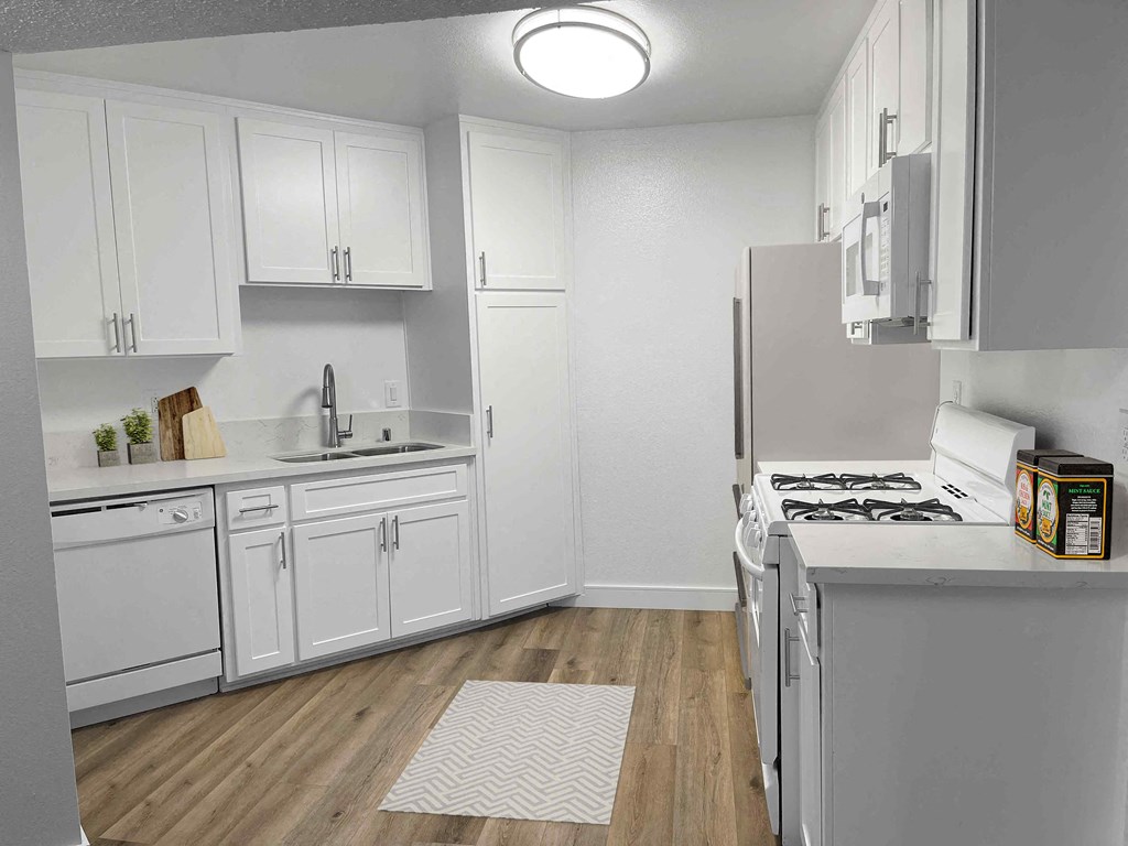 a kitchen with white cabinets and white appliances