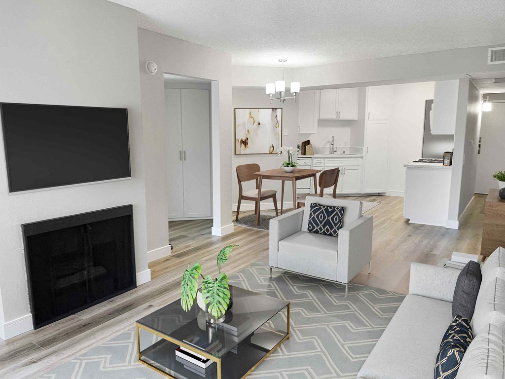 a living room with a fireplace and a kitchen in the background