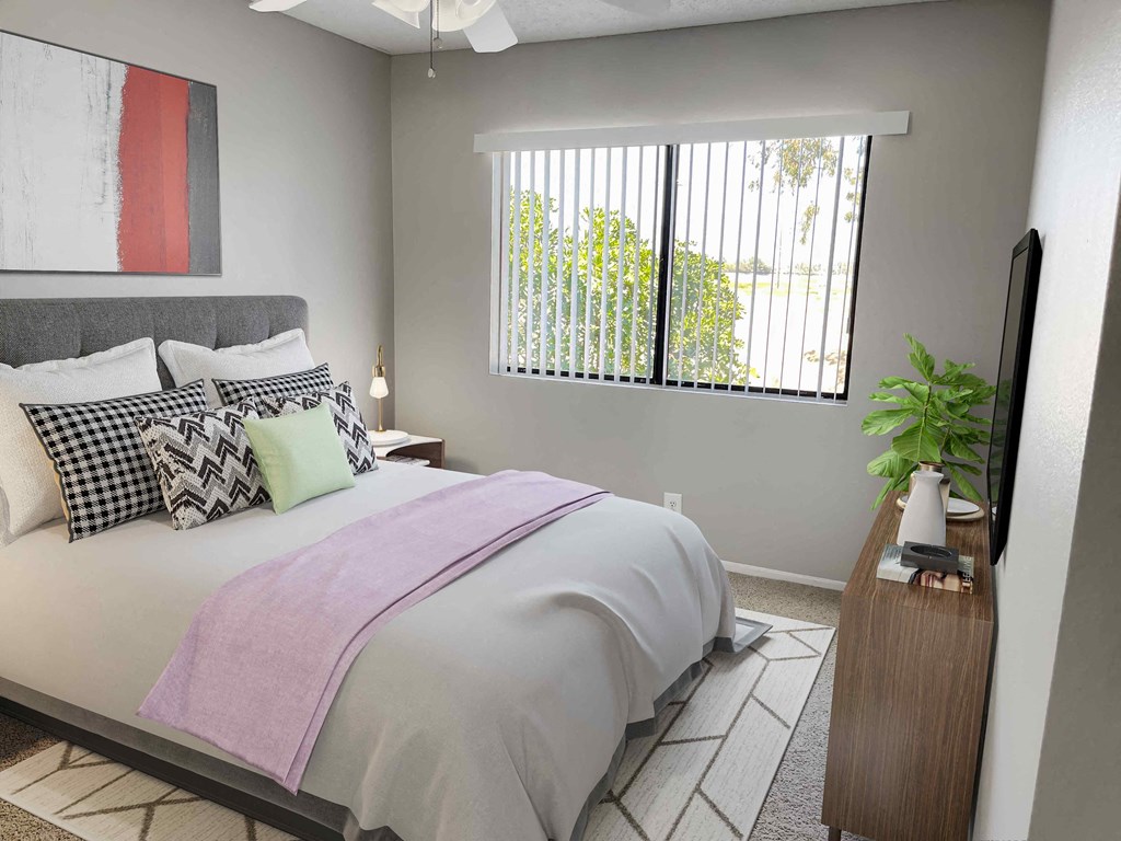 a bedroom with gray walls and a large window