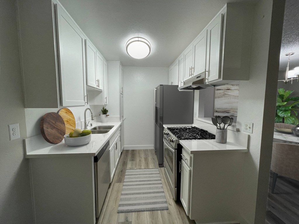 an empty kitchen with white cabinets and stainless steel appliances