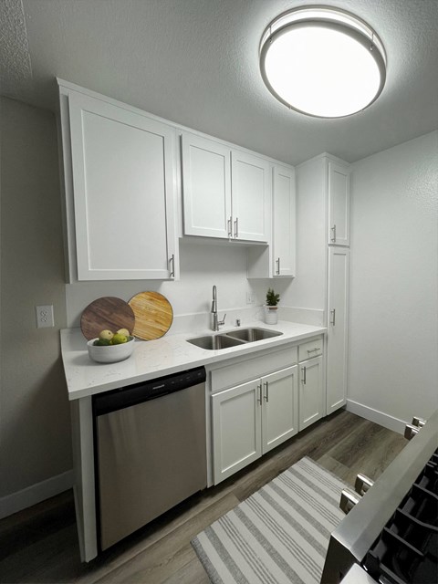 a small kitchen with white cabinets and a sink