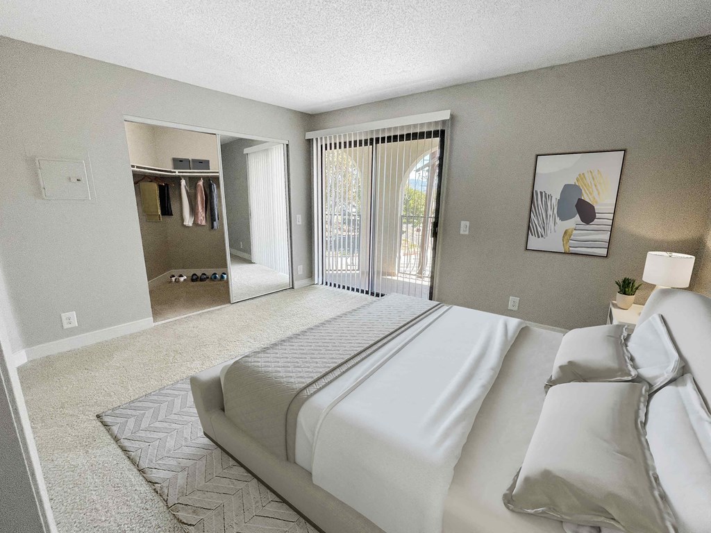 a bedroom with a large bed and a sliding glass door