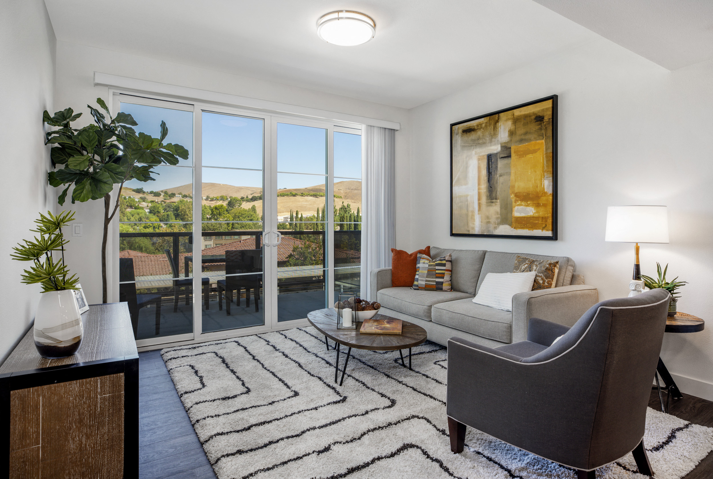 a living room with a couch and a chair and sliding glass doors to a balcony