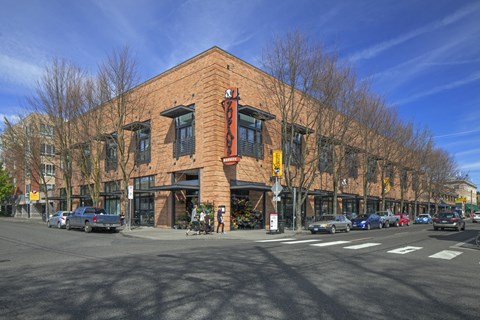 A red brick building with a yellow awning sits at a street corner.
