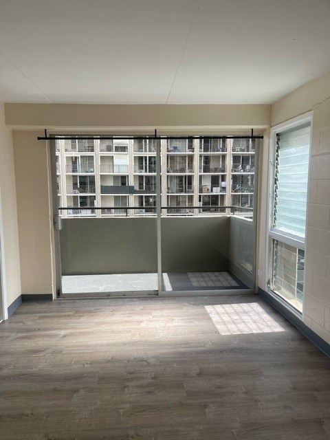 Napili Towers bedroom with a large window and a view of a building outside.