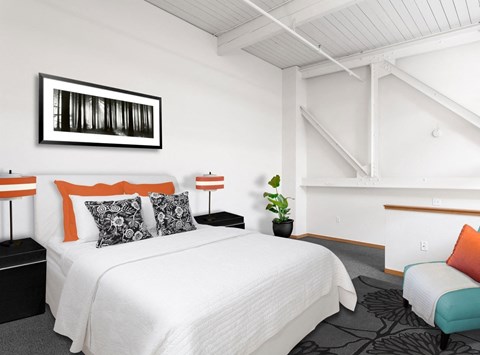 A bedroom with a white bed and a black and white picture on the wall.