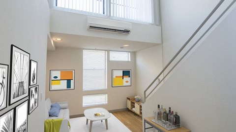 A living room with a white couch and a painting on the wall.