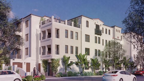 A white building with balconies and a person walking in front.