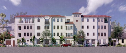 A row of multi-story buildings with balconies and trees in front.
