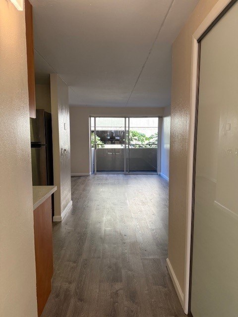 A long hallway with a white door on the right.