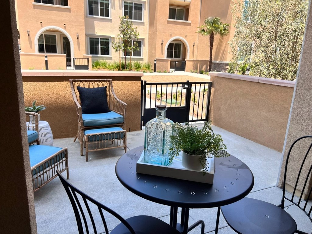 a balcony with a table and chairs and a vase on it