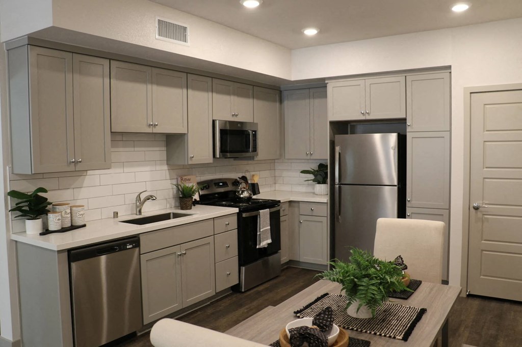a kitchen with white cabinets and stainless steel appliances