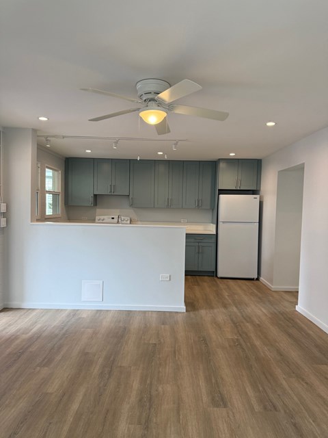 A kitchen with a white counter and a ceiling fan.