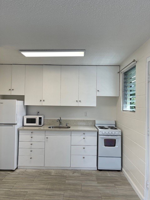 A kitchen with white appliances and cabinets.