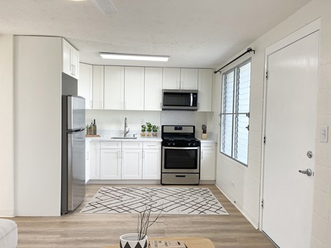 a kitchen with white cabinets and stainless steel appliances and a window