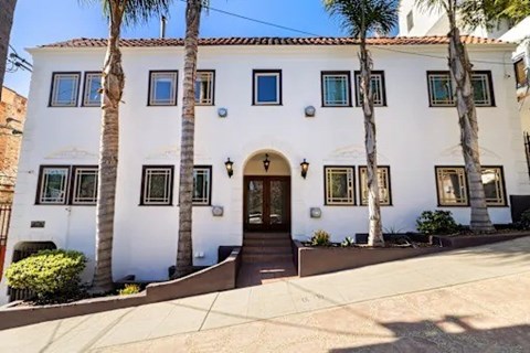 A white house with a brown door and windows.