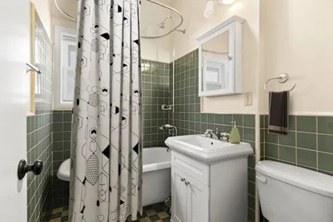 A white bathroom with a white tub and sink.
