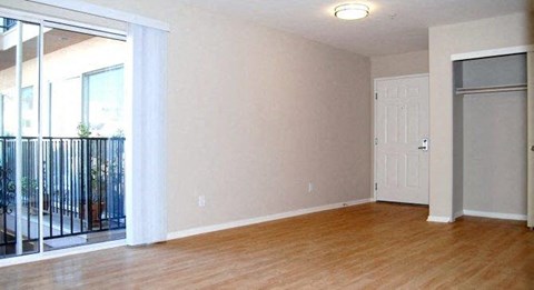 an empty living room with a door to a balcony